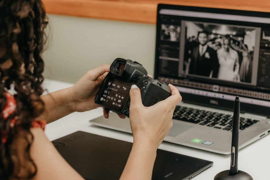 How to Remove a Watermark from a PDF A woman edits wedding photos on a laptop, holding a DSLR camera and using a graphics tablet.