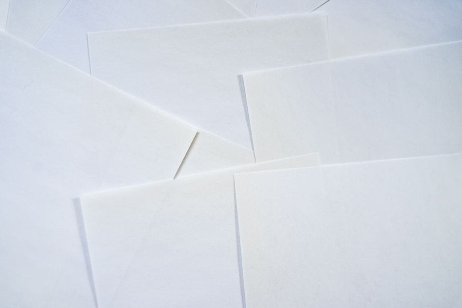 How to Remove Blank and Unwanted Pages From a Scanned PDF Abstract image featuring overlapping sheets of white paper creating geometric textures.