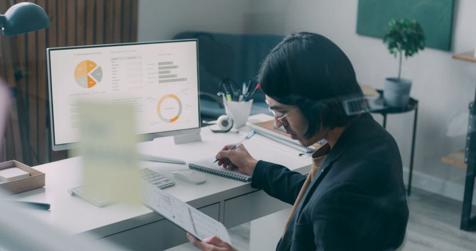 Business person reviewing analytics and charts at a modern office desk.