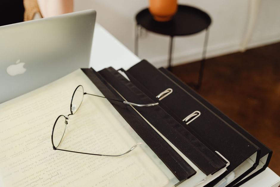 How to Fix a Sideways or Upside-Down Scanned PDF A neat office setup with binders, eyeglasses, and a laptop, perfect for productivity.