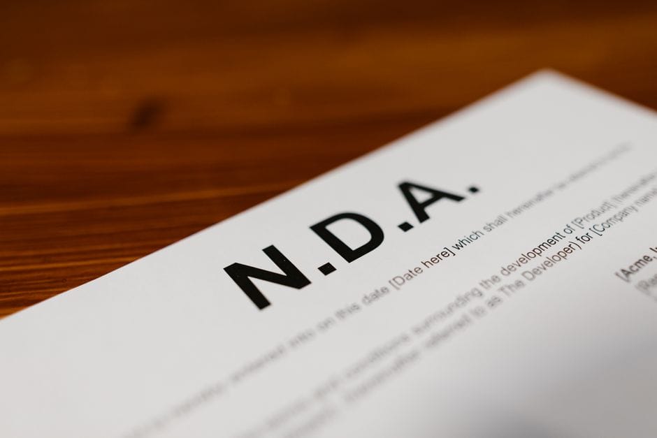 How to Compress a PDF Without Losing Quality Focused close-up of an NDA document on a wooden desk, highlighting contract details.