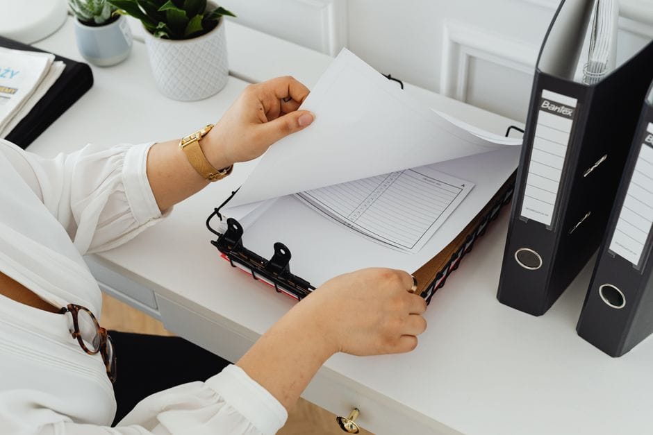 How to Merge, Reorder, and Organize PDF Files (Complete Guide) Business professional sorting through documents in a modern office setting.