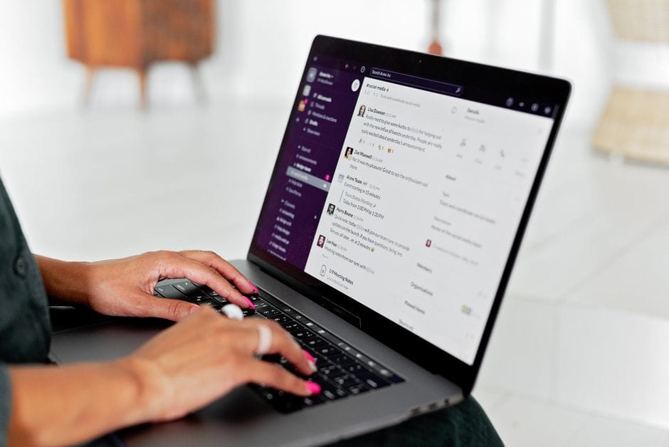 How to Reduce PDF File Size for Email Attachments A woman types on a laptop using a messaging app in a modern office setting.