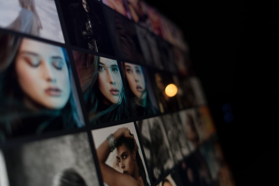 A digital display showcasing an array of female portraits, emphasizing diverse expressions and fashion styles.