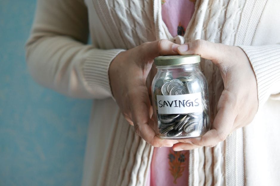 How to Combine PDF Files Without Adobe Acrobat Woman holding a jar labeled 'savings' filled with coins, representing financial savings.
